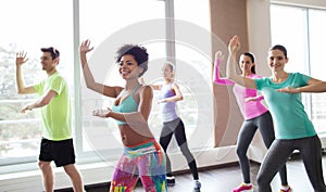 Group of smiling people dancing in gym or studio