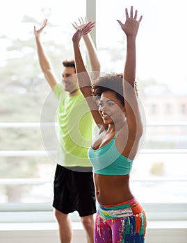Group of smiling people dancing in gym or studio