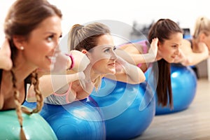 Group of smiling people doing aerobics with balls