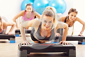 Group of smiling people doing push-ups