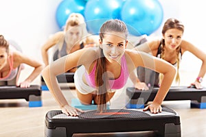 Group of smiling people doing push-ups