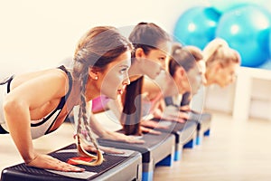 Group of smiling people doing push-ups