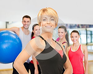 Group of smiling people exercising in the gym