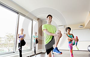 Group of smiling people exercising in gym