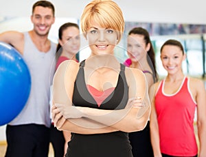 Group of smiling people exercising in the gym