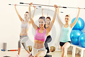 Group of smiling people lifting barbells