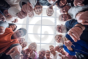 Group of smiling people pointing at the camera