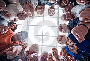 Group of smiling people pointing at the camera