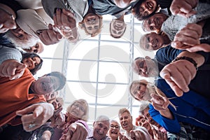 Group of smiling people pointing at the camera