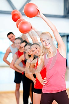 Group of smiling people working out with ball