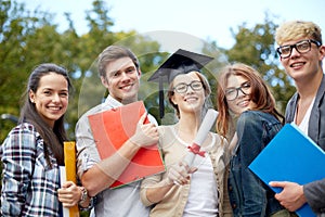 Group of smiling students with diploma and folders