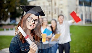 Group of smiling students with diploma and folders