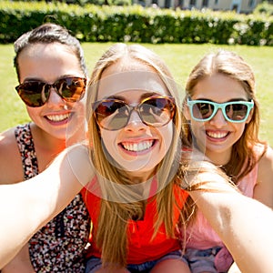 Group of smiling teen girls taking selfie in park