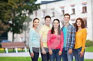 Group of smiling teenagers over campus background