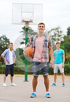 Group of smiling teenagers playing basketball