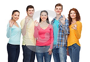 Group of smiling teenagers showing ok sign