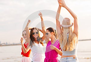 Group of smiling women dancing on beach