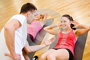 Group of smiling women doing sit ups in the gym photo