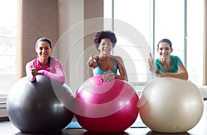 Group of smiling women with exercise balls in gym