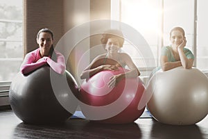 Group of smiling women with exercise balls in gym