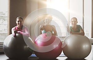 Group of smiling women with exercise balls in gym