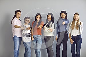 Group of smiling women pointing at camera, inviting you to join their successful team