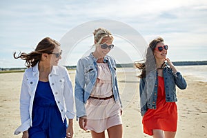 Group of smiling women in sunglasses on beach