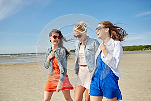 Group of smiling women in sunglasses on beach