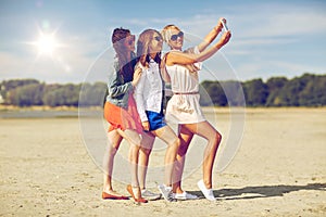 Group of smiling women taking selfie on beach