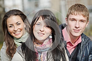 group of smiling young people or students outdoors