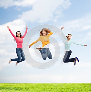 Group of smiling young women jumping in air