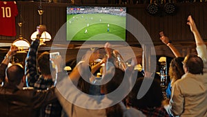 Group of Soccer Fans Watching a Live Football Match in a Sports Bar. People Standing in Front of a