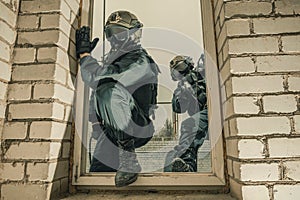 Group of special forces fighters storm the building through the window. Training sessions of the SWAT team. Anti-terror concept.