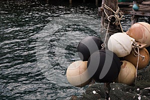 Group of spherical boat fenders and buoys with ocean water at dock