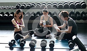 Group of sportive people in a gym training - Multiracial group of athletes sitting on floor relax after stretching