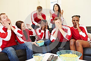 Group Of Sports Fans Watching Game On TV At Home