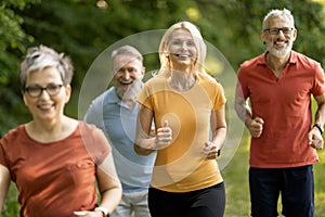 Group of sporty mature people jogging at park together