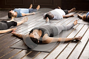 Group of sporty people in Savasana pose