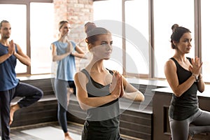 Group of sporty people in Vrksasana exercise, close up