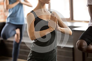 Group of sporty people in Vrksasana exercise, close up