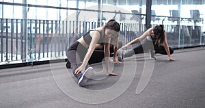 Group of sporty young asian women in sportswear warming up with gymnastics and stretching exercises