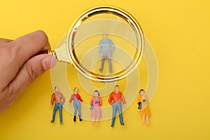 The group of staff, armed with a magnifying glass, scoured the job applications, searching for the ideal candidate to hire photo