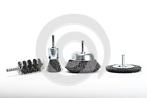 Group of steel spike brushes for drill machine on white background