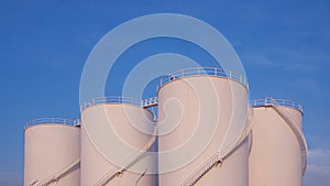Group of Storage Fuel Tanks in Oil Industrial area against blue sky background in widescreen view