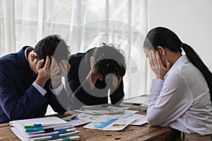 A group of stressed-out young Asian businessmen searching for a solution to a problem at a partnership meeting