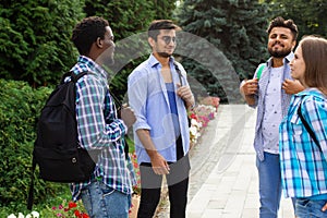 Group of studens stand at the campus and discuss lessons