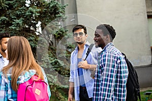 Group of studens stand at the campus and discuss lessons