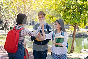 Group of student happy young people touch hands outdoors, Diverse Young Students Book Outdoors Concept