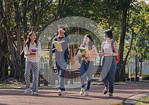 Group of student happy young people walking outdoors, Diverse Young Students Book Outdoors Concept