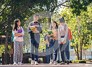 Group of student happy young people walking outdoors, Diverse Young Students Book Outdoors Concept